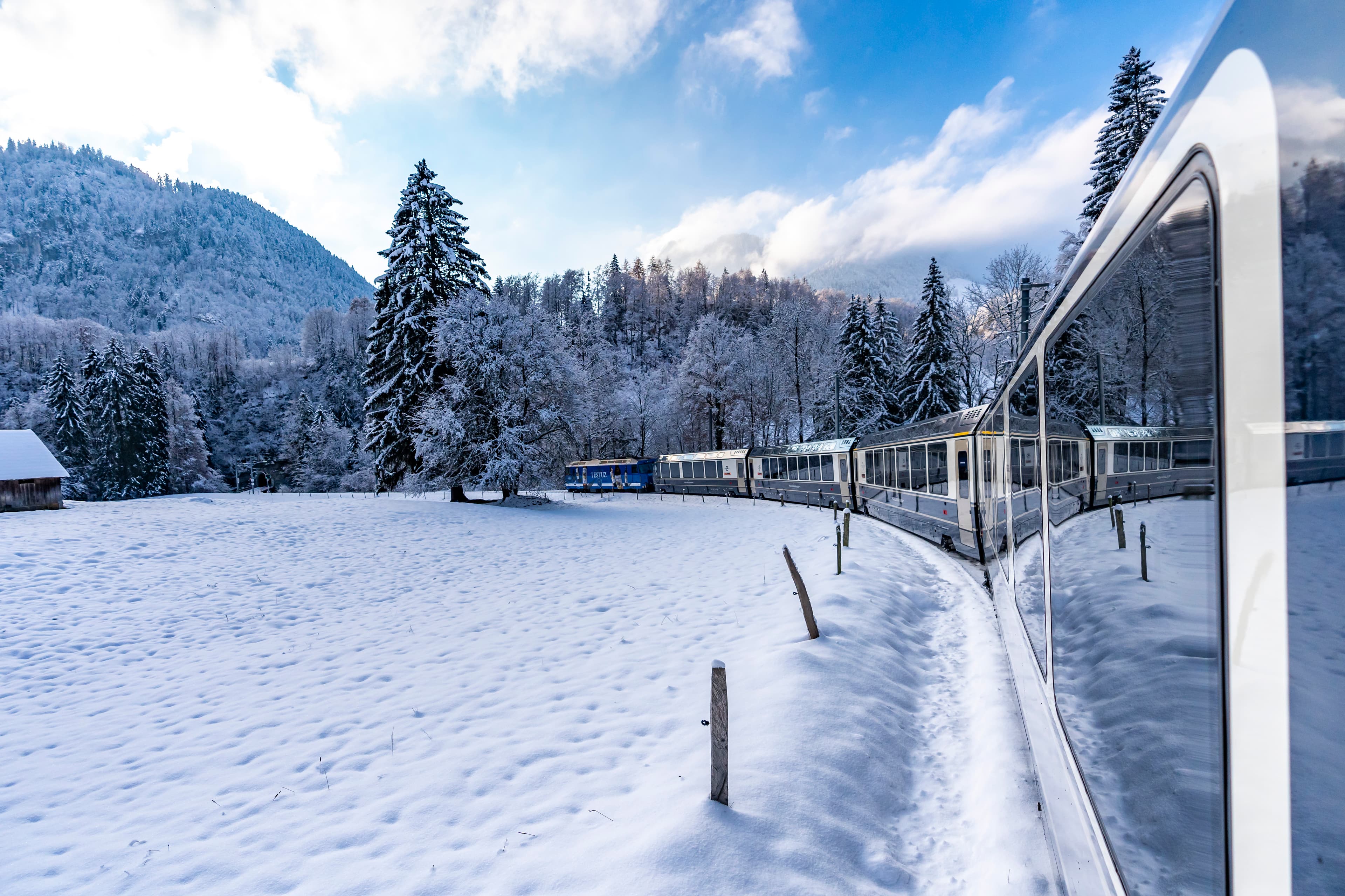 Tren panorámico atravesando paisaje alpino de invierno