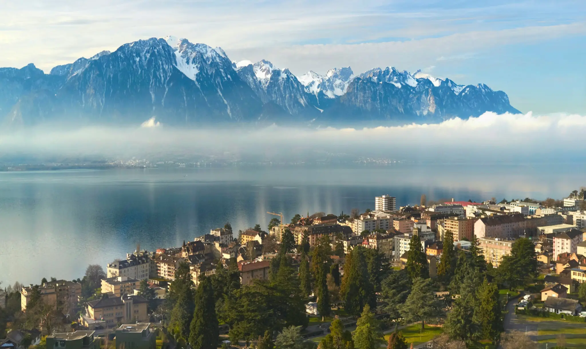 Montreux junto al lago Lemán con montañas nevadas entre la niebla