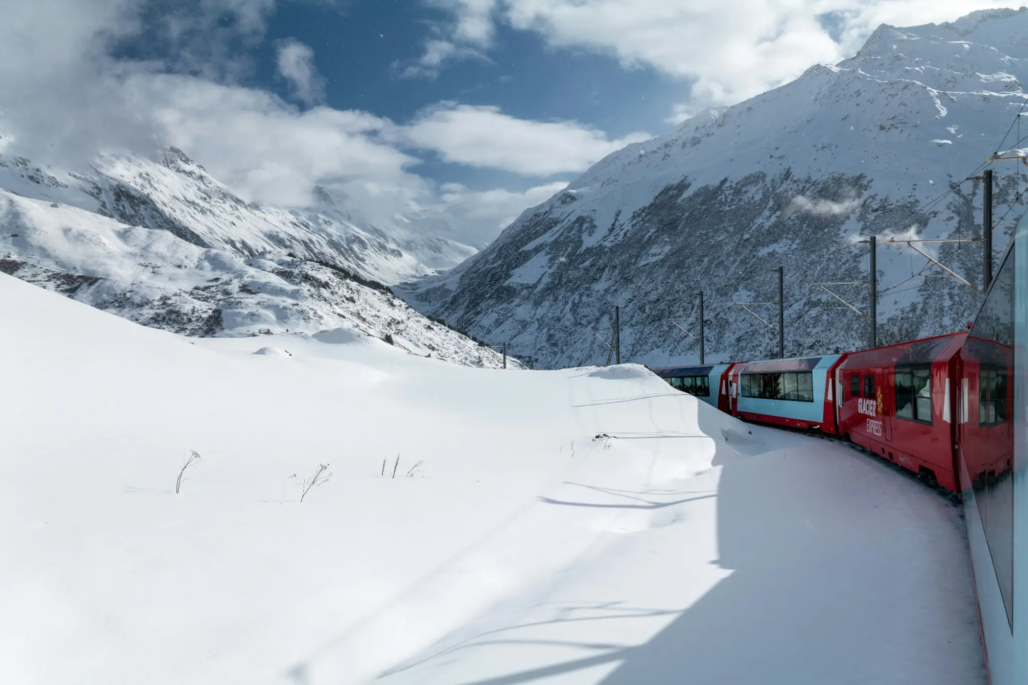 Glacier Express recorriendo una curva entre montañas nevadas
